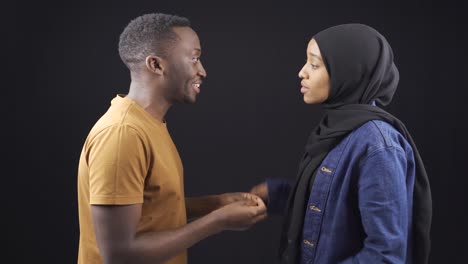 African-muslim-couple-arguing,-fighting-and-judging-each-other-on-black-background.